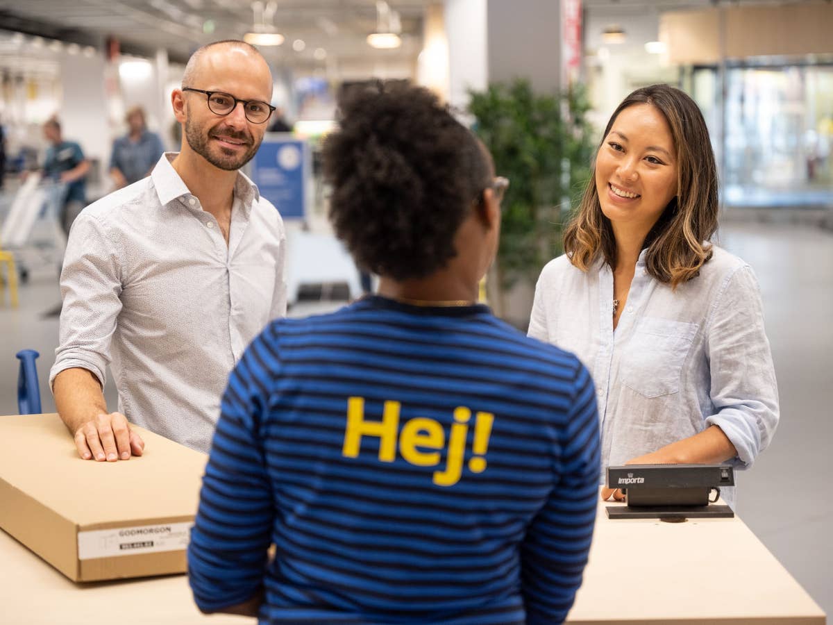 Zwei Kunden sprechen mit einer Ikea-Mitarbeiterin