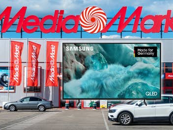 Im Hintergrund ein MediaMarkt-Store, davor ein Samsung 4K-Fernseher