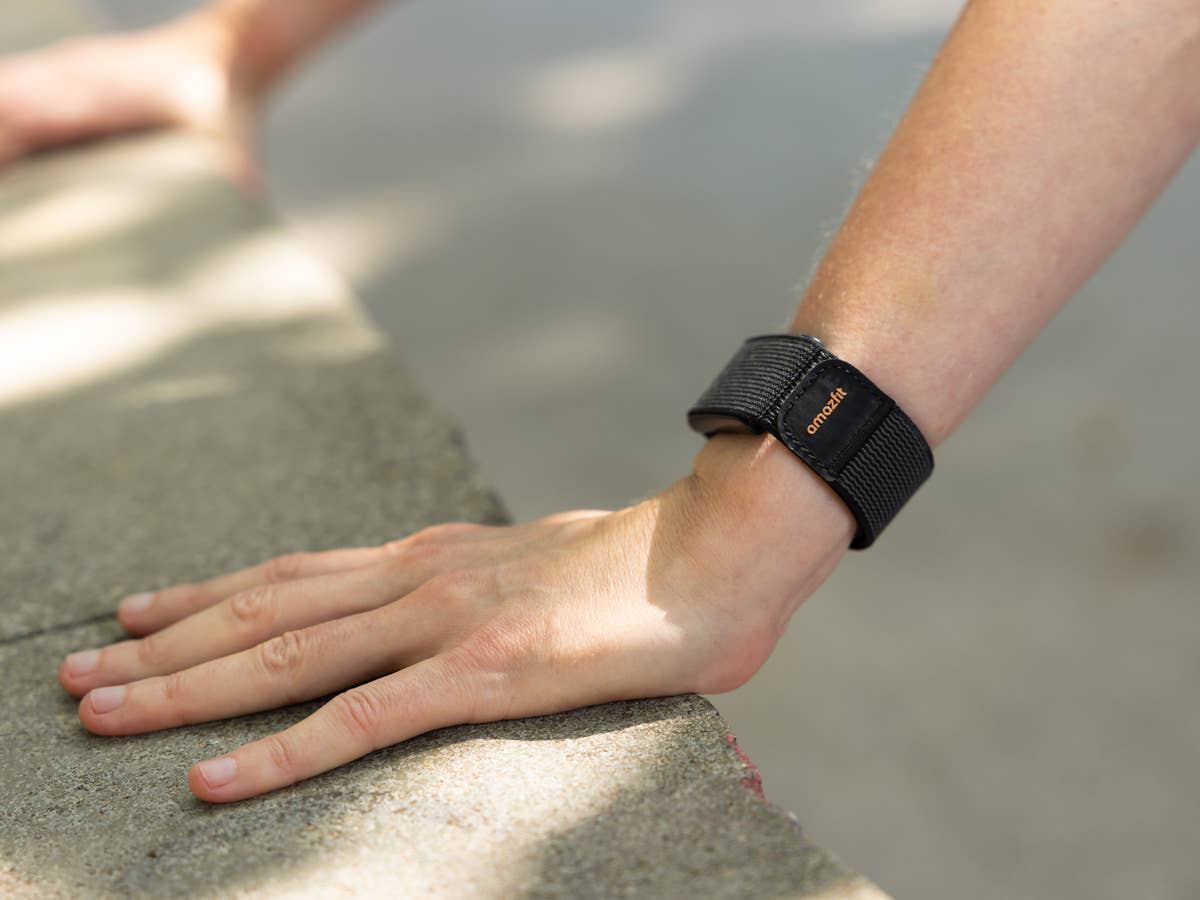 Eine Nahaufnahme einer Hand, die auf einer Oberfläche ruht und ein Amazfit Helio-Armband am Handgelenk trägt.