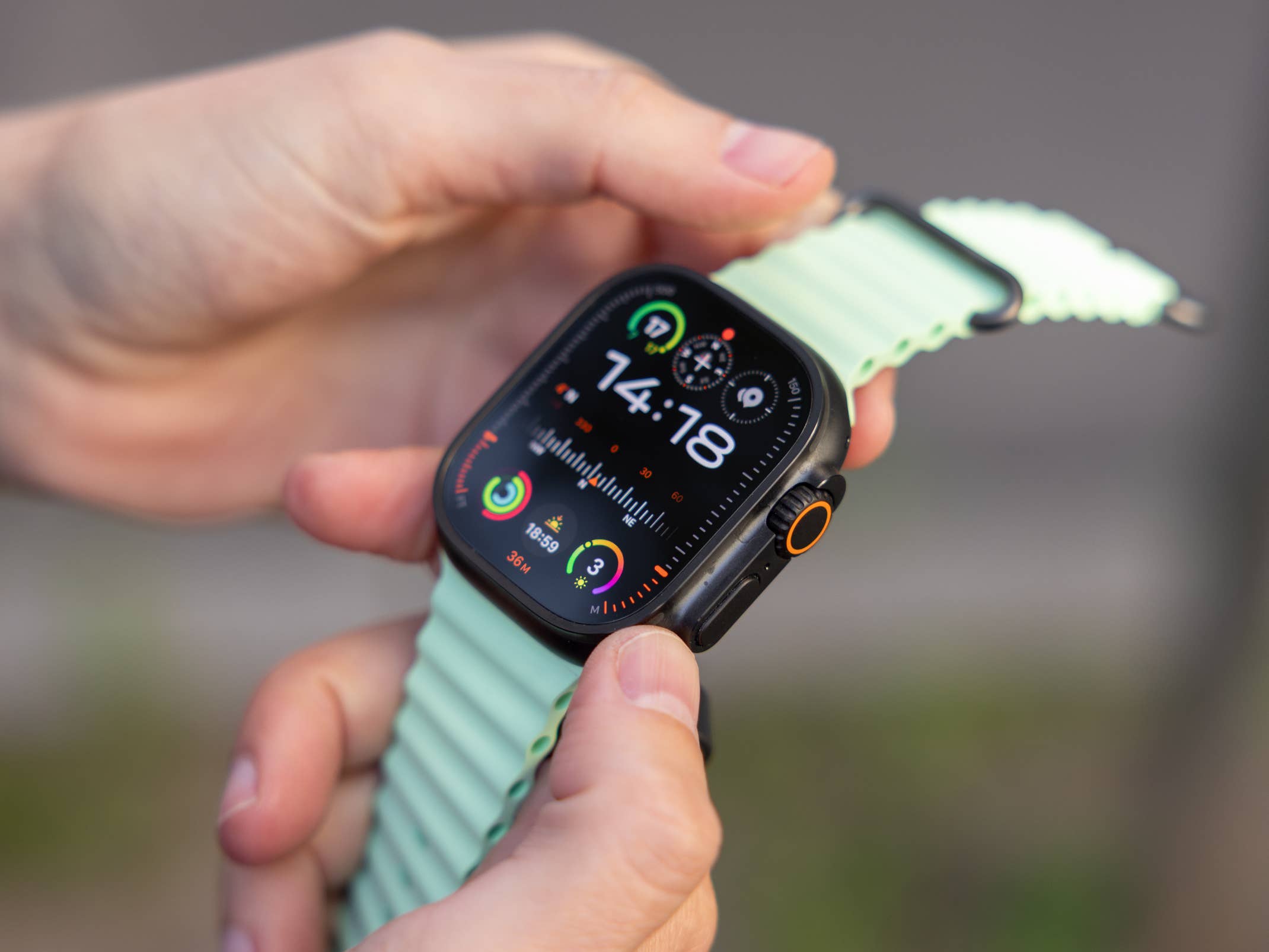 Apple Watch Ultra 3 mit grünem Armband und aktivem Zifferblatt in Nahaufnahme