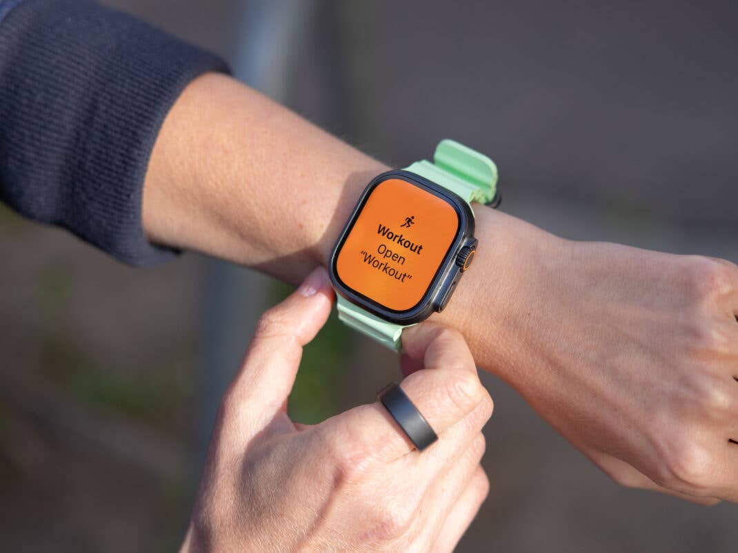 Eine Person mit einer Apple Watch zeigt 'Workout Open Workout' auf dem Bildschirm an.