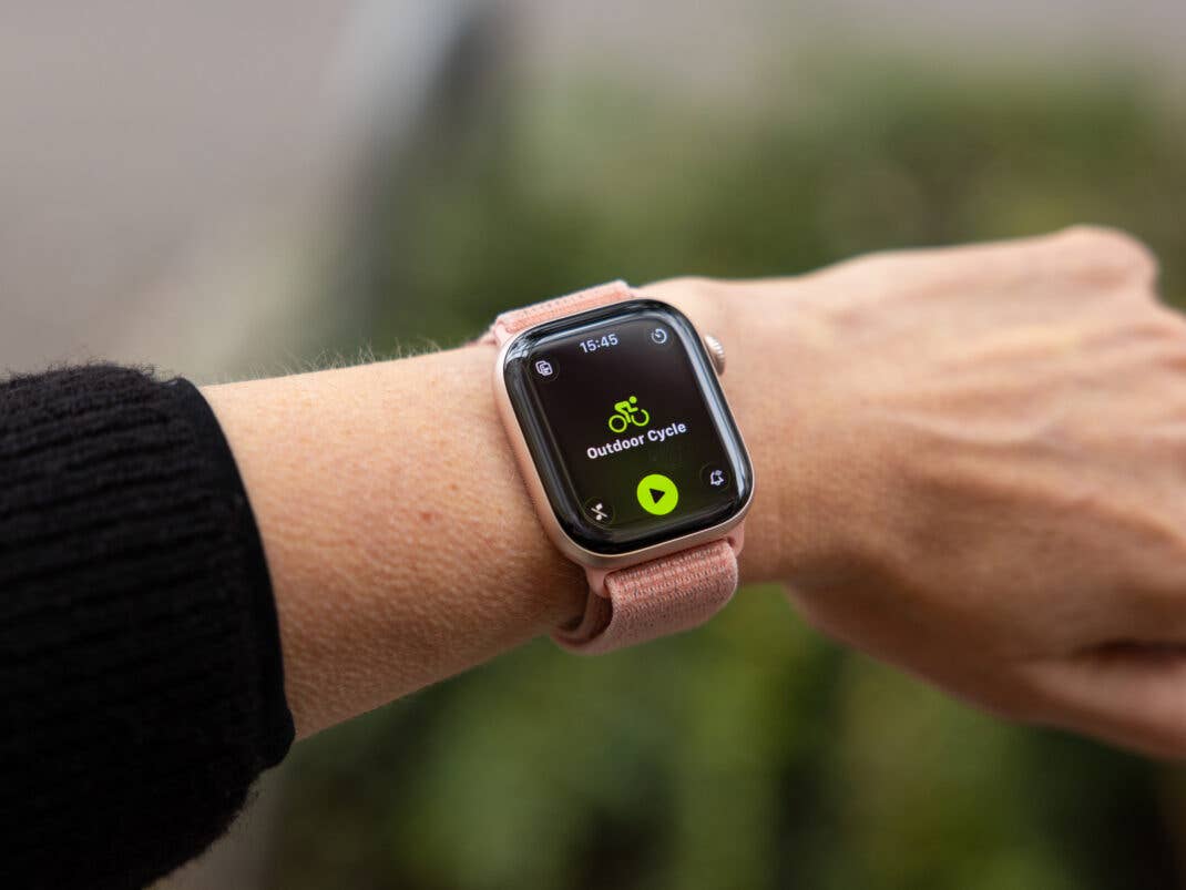 Eine Nahaufnahme einer Apple Watch, die 'Outdoor Cycle' mit einem Wiedergabeknopf anzeigt.