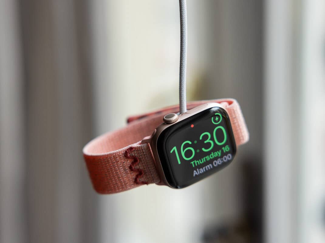 Eine pinkfarbene Apple Watch zeigt die Uhrzeit 16:30 auf ihrem Bildschirm.