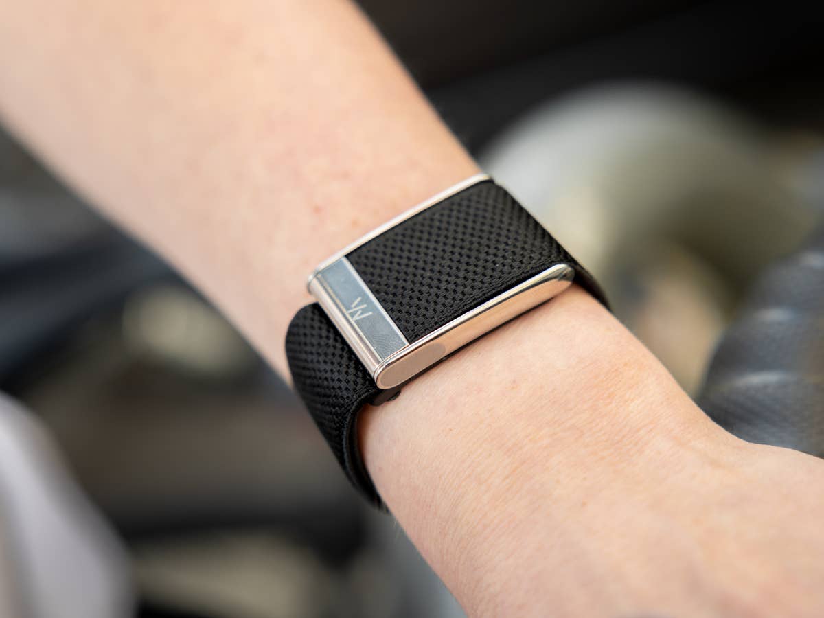 Whoop MG Eine Nahaufnahme einer schwarzen Smartwatch am Handgelenk mit einem eleganten Design.