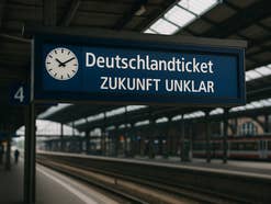 Ein Bahnsteig an einem deutschen Bahnhof. Auf der Anzeige steht: Deutschlandticket – Zukunft unklar.