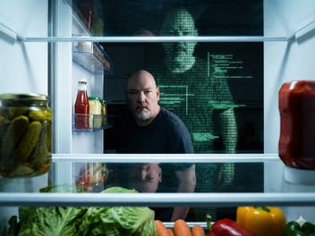 Casi schaut in den offenen Kühlschrank, hinter ihm eine Silhouette aus Code im Matrix-Stil.