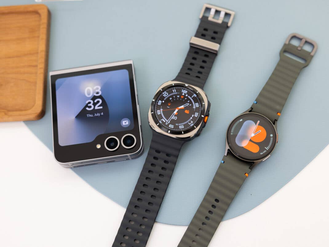 Samsung Galaxy Watch 7 und Watch Ultra neben einem zusammengeklappten Samsung Galaxy Z Flip 6.