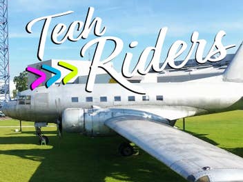 Ein Vintage-Flugzeug auf grünem Gras mit dem Text 'Tech Riders.