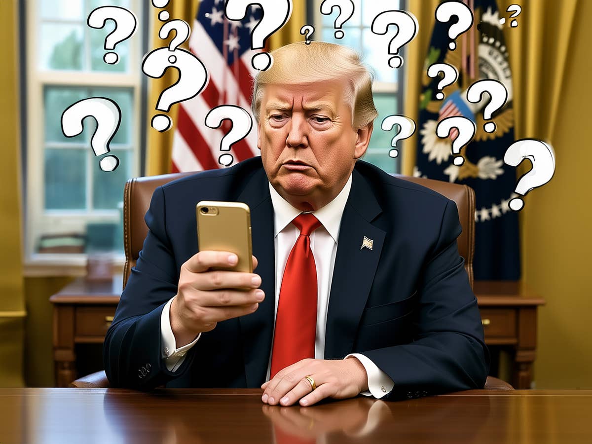Donald Trump sitzt an seinem Schreibtisch und schaut verwirrt auf sein Handy, im Hintergrund Fahnen.