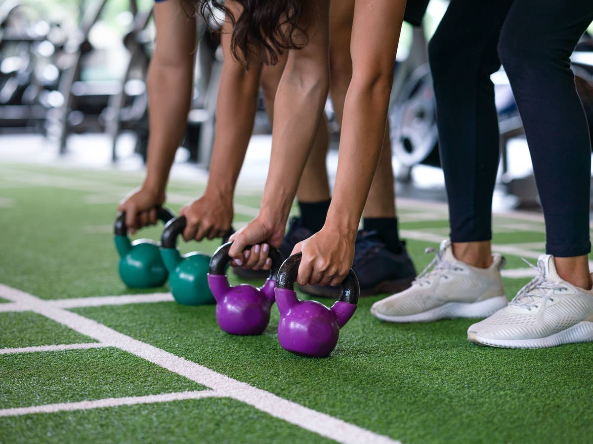 Junge Frauen und Männer beim funktionellen Training im Fitnessstudio – körperliche Belastung, wie sie Wearables erfassen und analysieren können.