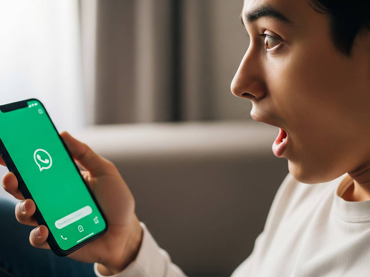 Eine Person überrascht, während sie WhatsApp auf einem Smartphone nutzt.