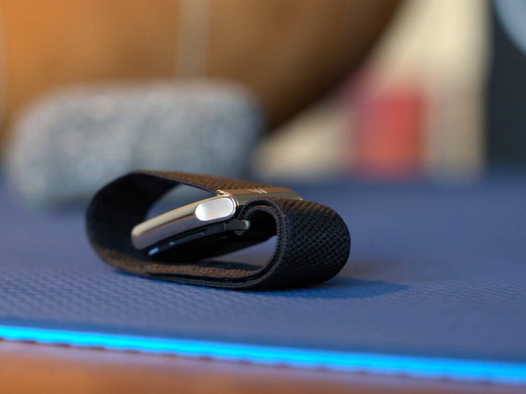 Ein Whoop MG Sensor-Gerät liegt auf einer blauen Matte, mit unscharfem Hintergrund.