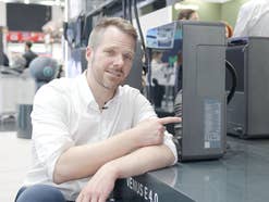 Redakteur zeigt auf Stromspeicher mit Lithium-Technologie