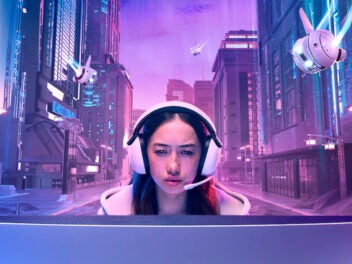 Ein Mädchen sitzt mit einem INZONE Headset vor einem INZONE Monitor