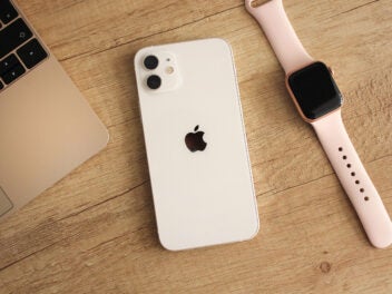 iPhone 12 liegt neben einer Apple Watch und einem MacBook