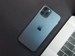 iPhone 12 Pro in Blau neben einem MacBook