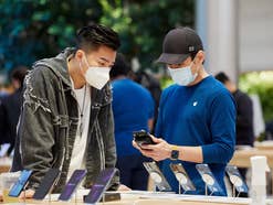 Symbolbild iPhone 13 mit zwei Personen im Apple Store