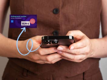 Eine Frau hält ein iPhone in ihren Händen, ein eingeblendeter Hinweis bewirbt einen Unlimited-Tarif