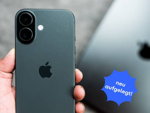 Im Vordergrund hält eine Hand ein iPhone 17 mit der Rückseite in die Kamera, im Hintergrund liegt ein MacBook