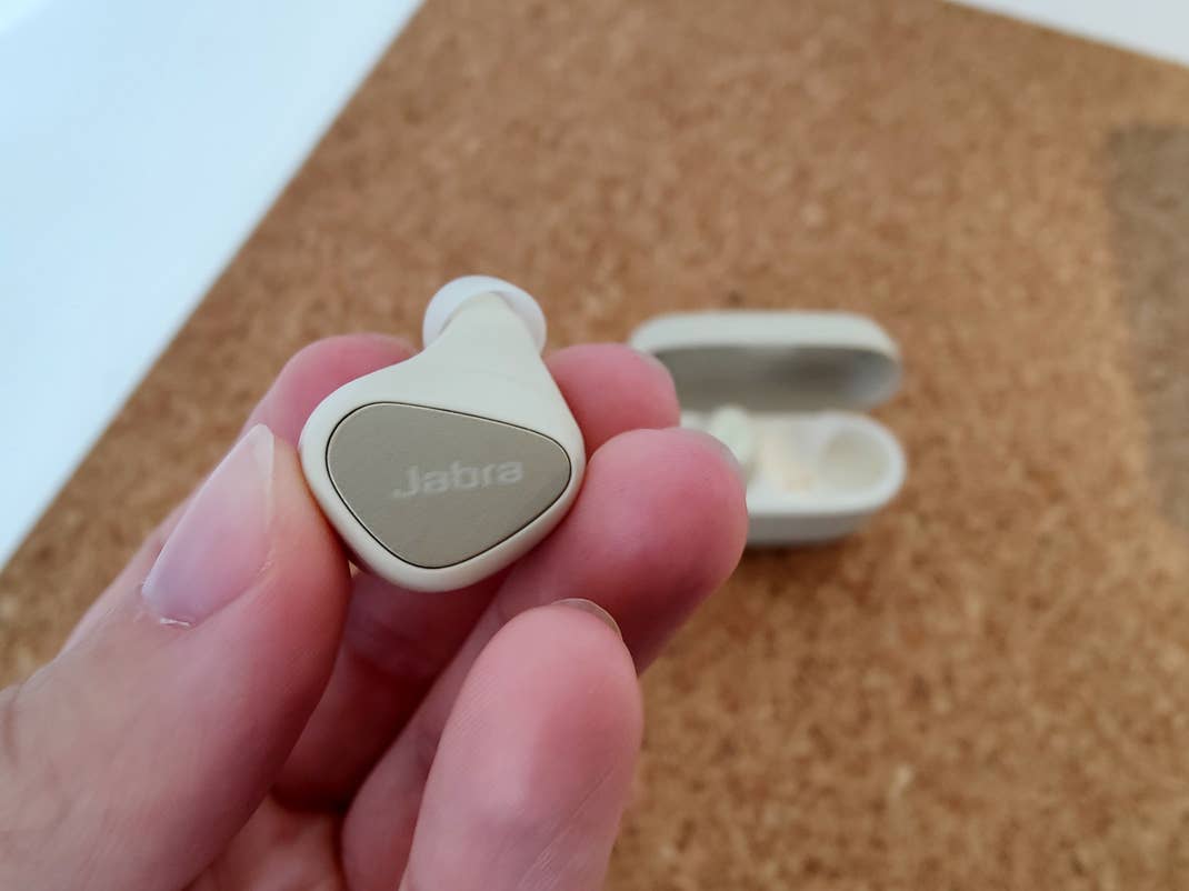 Ein Kopfhörer der Jabra Elite 5 in einer Hand.