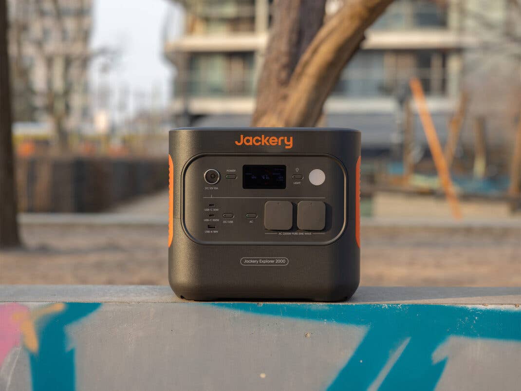 Jackery Explorer 2000 v2 Frontansicht und auf einer Mauer stehend.