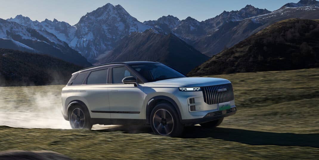Jaecoo 7 PHEV während der Fahrt vor Bergpanorama.
