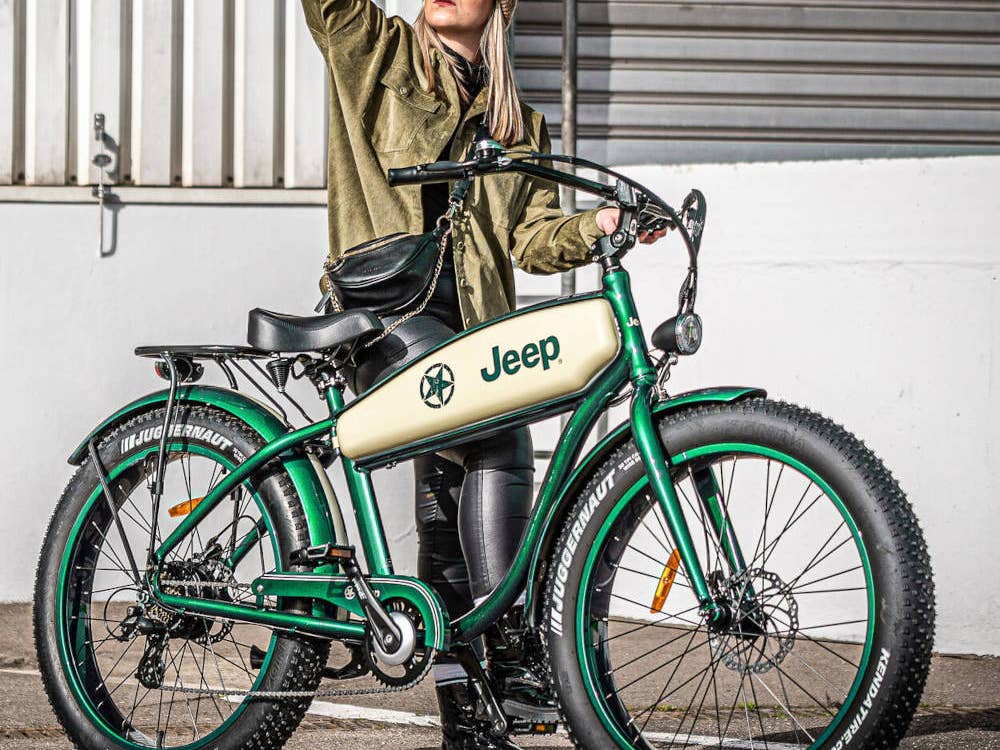 Frau steht hinter dem JEEP Cruise E-Bike CR 7004 auf der Straße.