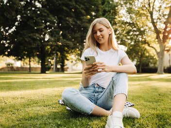 Junge Frau mit Smartphone im Park