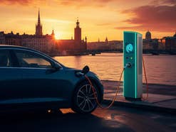 E-Auto an einer Ladesäule vor der Skyline von Stockholm.