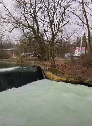 Der Münchner Eisbach und dahinter eine Wiese
