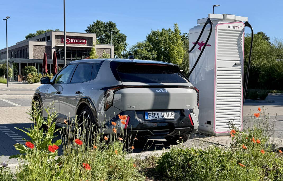 Kia EV4 an einer Ladesäule von IONITY in der Heckansicht.
