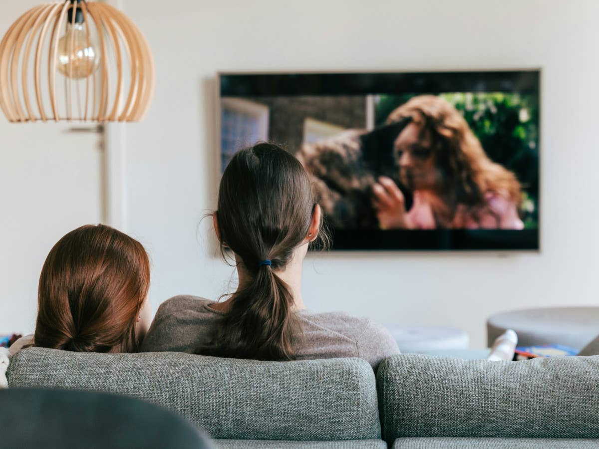 TV-Sender Kika steht vor dem Aus Ein Erwachsener und ein Kind sitzen auf dem Sofa und gucken TV.
