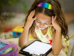 Kind schaut auf ein Tablet Display