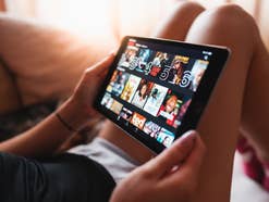 Eine Person schaut auf einem Tablet auf den Netflix-Startbildschirm