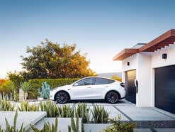 Tesla Model Y steht in einer Einfahrt.