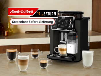 Kaffeevollautomat der Marke Krups steht auf einer Küchentheke mit verschiedenen Kaffeegetränken drumrum stehend. Logo von MediaMarkt und Saturn, sowie kostenlose Sofort-Lieferung eingeblendet.