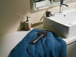 Laifen Neo Special Haartrockner liegt auf einem Handtuch in einem Badezimmer