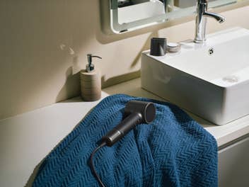 Laifen Neo Special Haartrockner liegt auf einem Handtuch in einem Badezimmer