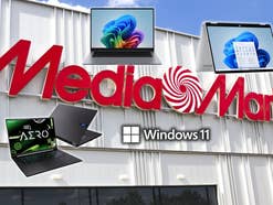 MediaMarkt-Store im Hintergrund, vorne Laptops von HP, Samsung und Gigabyte sowie das Windows 11 Logo