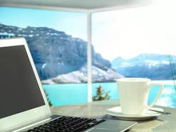 Internet im Ausland nutzen: Ein Laptop vor einem Berg-Panorama