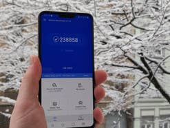 LG V40 ThinQ mit einem Benchmark-Wert auf dem Display vor verschneiter Kulisse