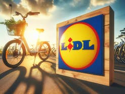 Ein Logo von Lidl im Sonnenlicht neben einem Fahrrad.