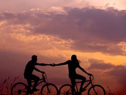 Liebesfilme Pärchen fährt Fahrrad im Sonnenuntergang.