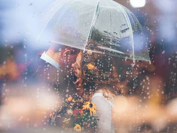Ein Pärchen umarmt sich unter einem Regenschirm.