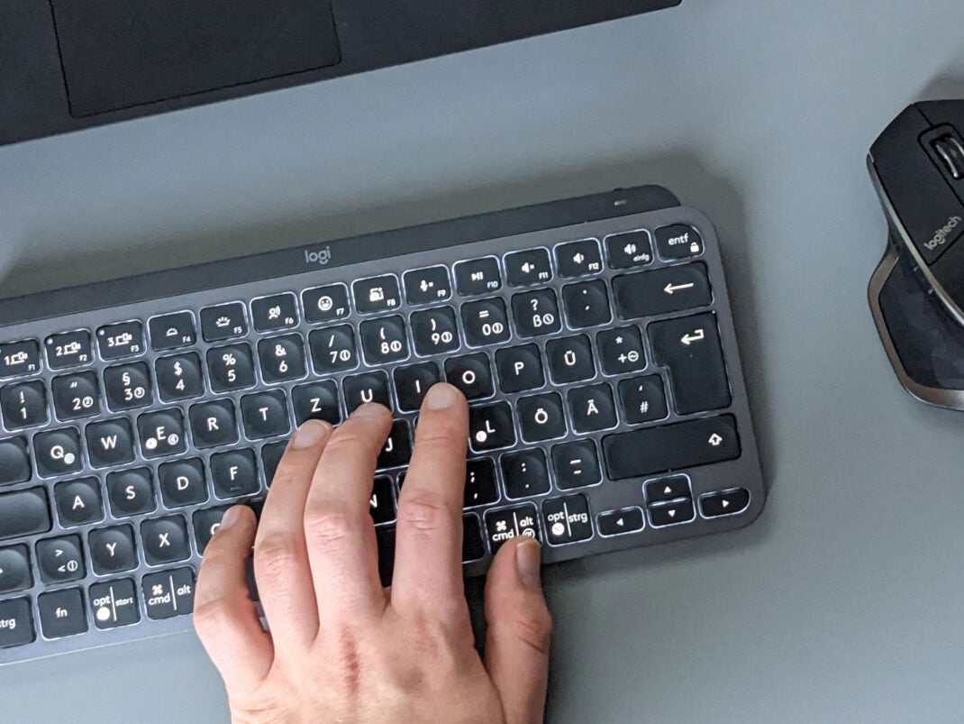 Logitech MX Keys Mini mit Laptop, Maus und Hand