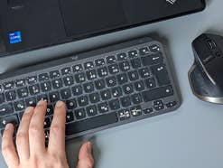 Logitech MX Keys Mini mit Laptop, Maus und Hand