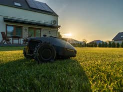 Ein Mähroboter bei Dämmerung