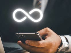 Mann hält Smartphone in der Hand, darüber das Unendlichkeitszeichen