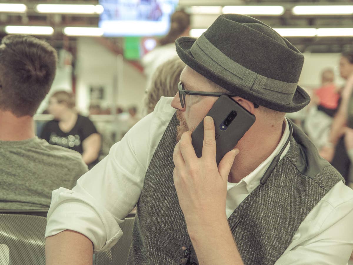 Mann telefoniert mit Handy im Flughafen