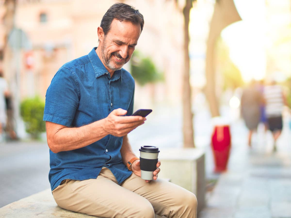 Mann mit Kaffee und Smartphone